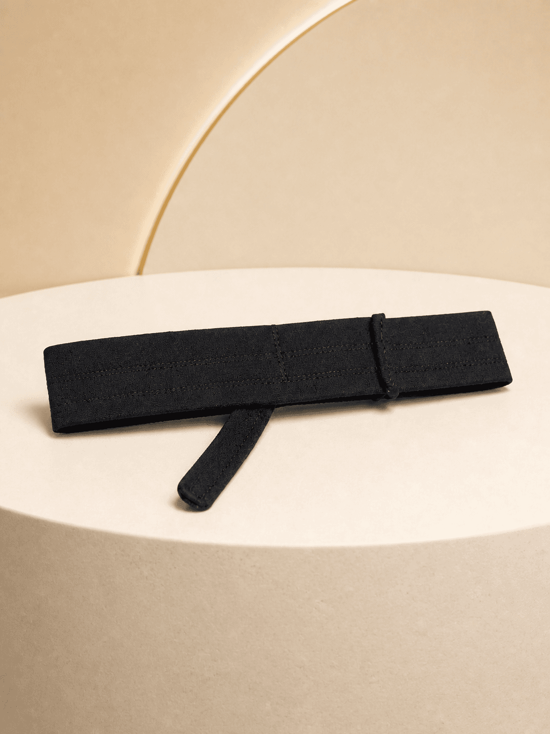 Refined black BeardBand presented on a warm cream studio plinth